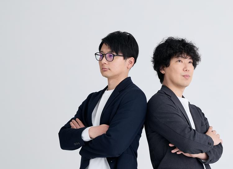 腕を組んでいる2名の男性写真